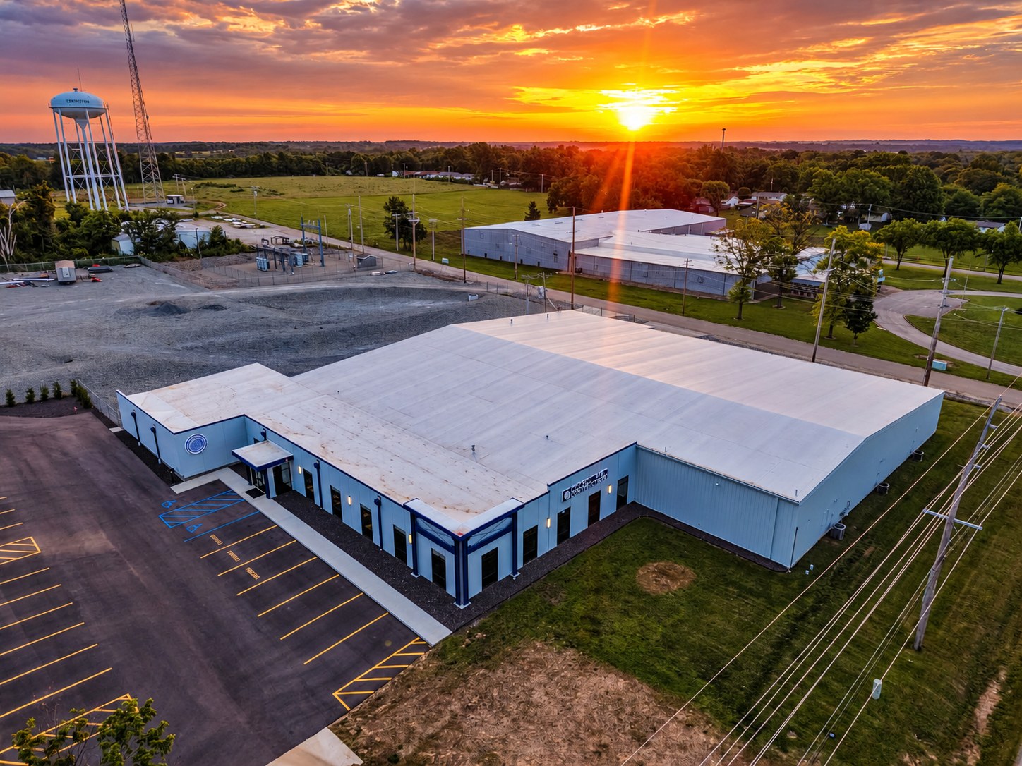 Aerial of commercial facility at sunset with water tower - HelixMind Real Estate Media