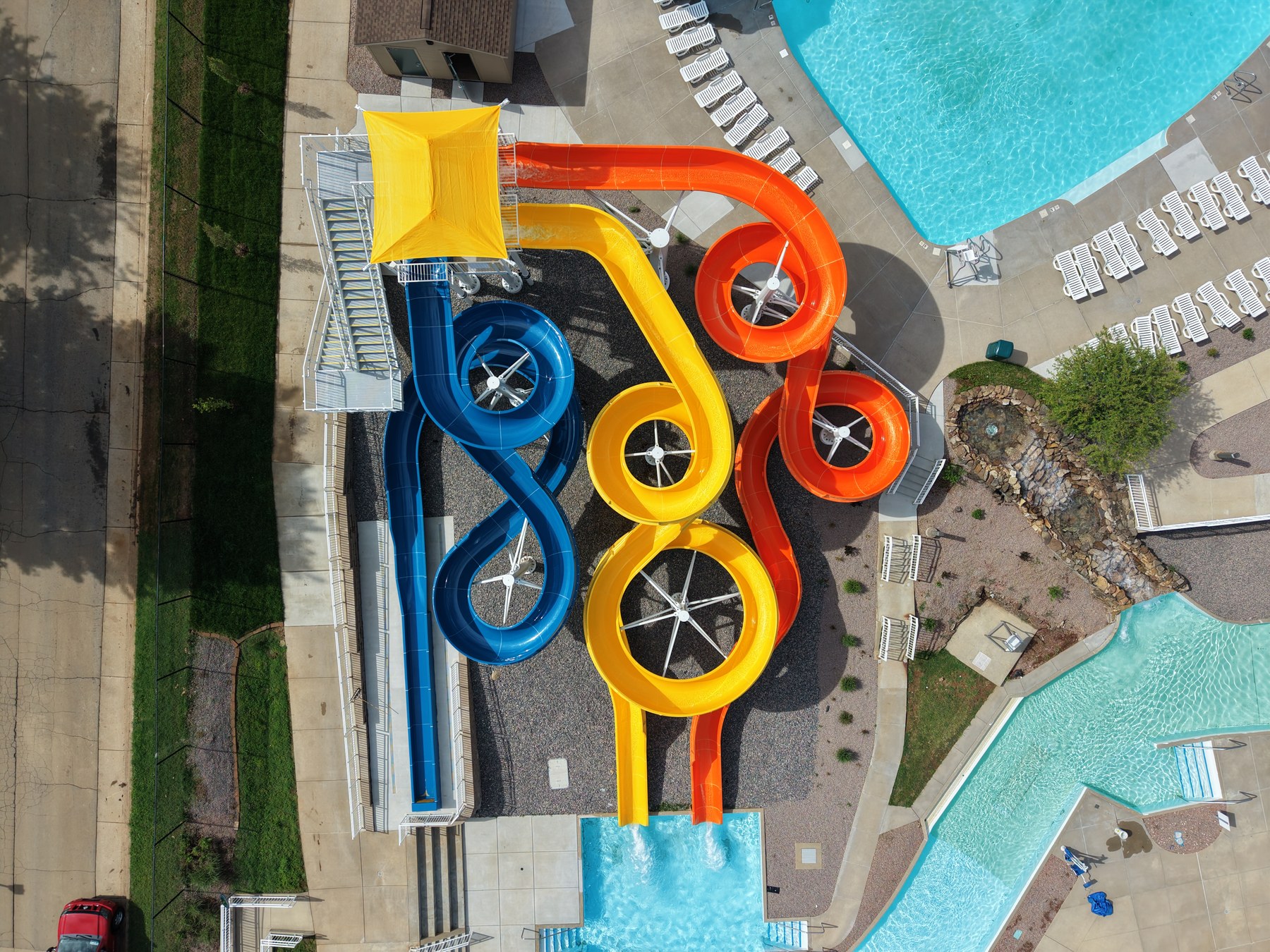 Aerial view of water park slide tower with color-coded slides - HelixMind Real Estate Media