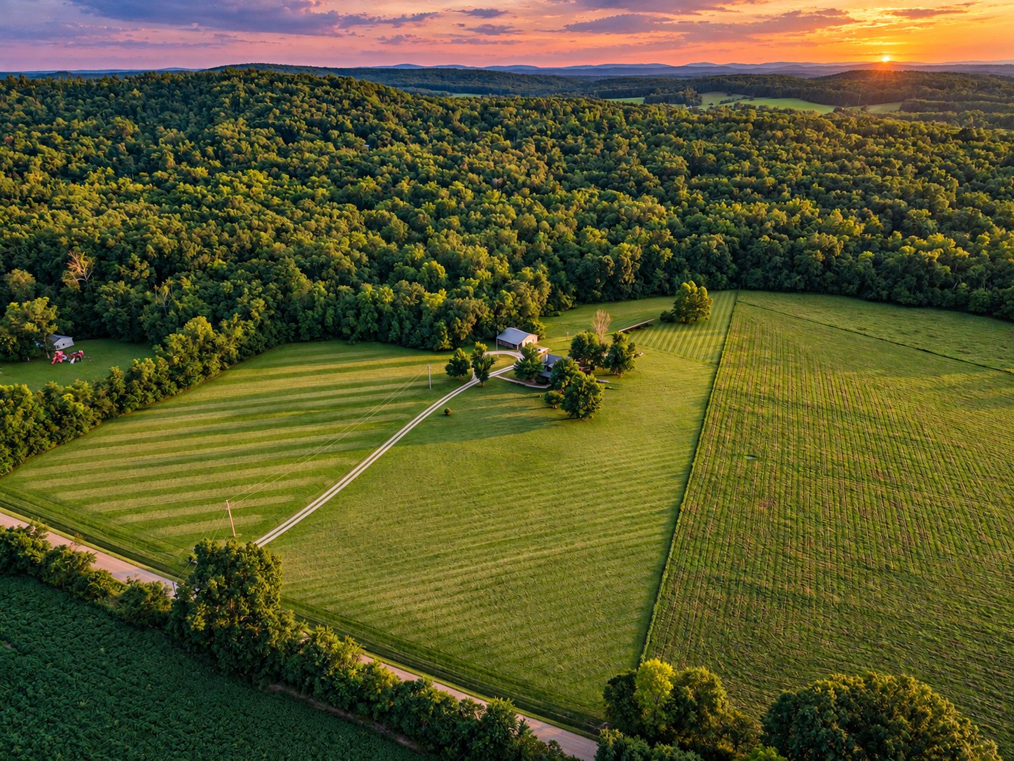 Aerial of farmhouse and mowed fields at sunset - HelixMind Real Estate Media