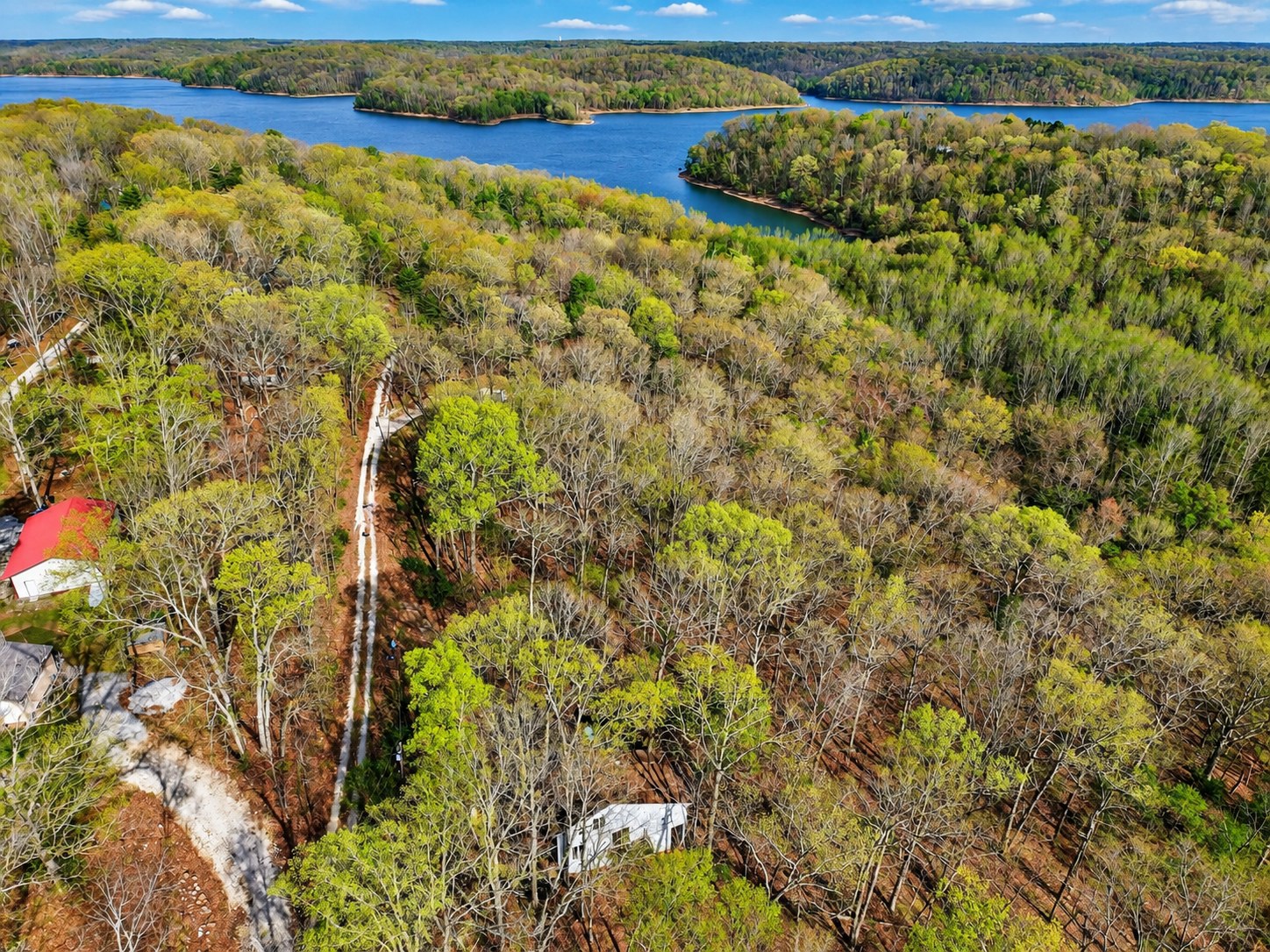 Aerial of lakefront wooded property in spring - HelixMind Real Estate Media