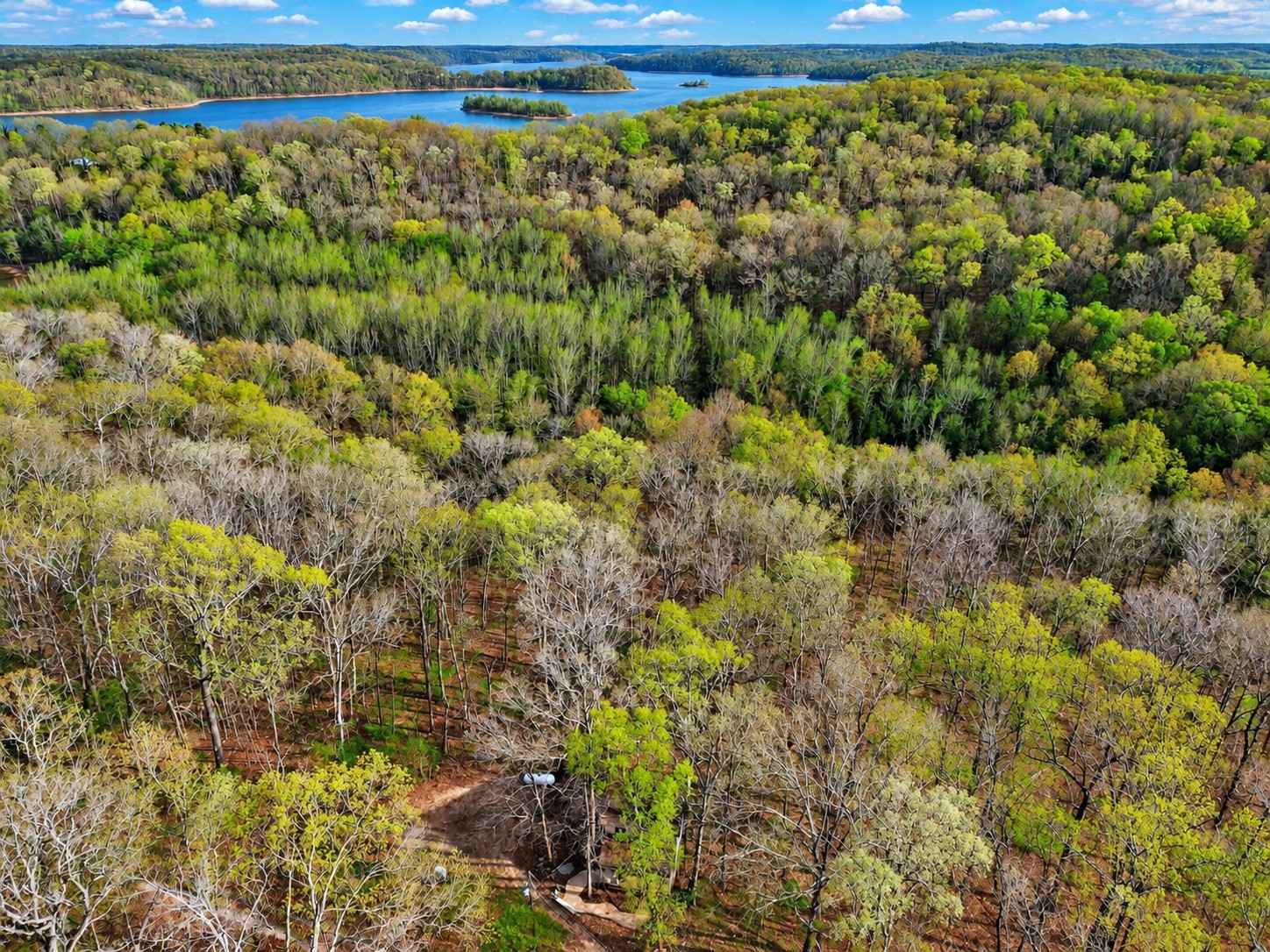 Aerial drone view of wooded rural acreage listing