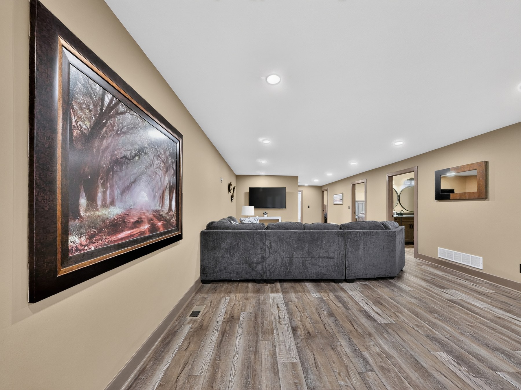 Basement lounge with sectional and media wall - HelixMind Real Estate Media