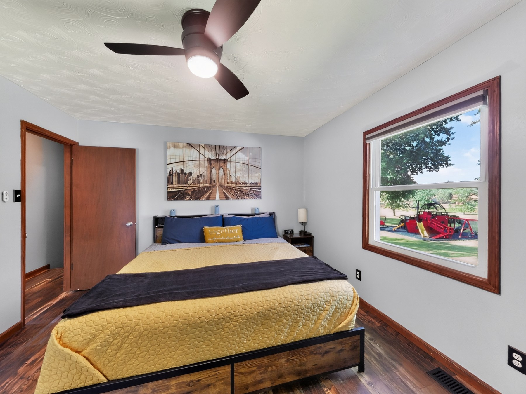 Styled bedroom with skyline art and yard view - HelixMind Real Estate Media