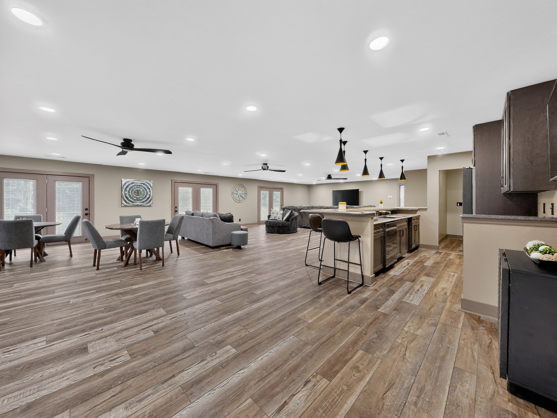 Open bonus room with dining, living, and wet bar - HelixMind Real Estate Media