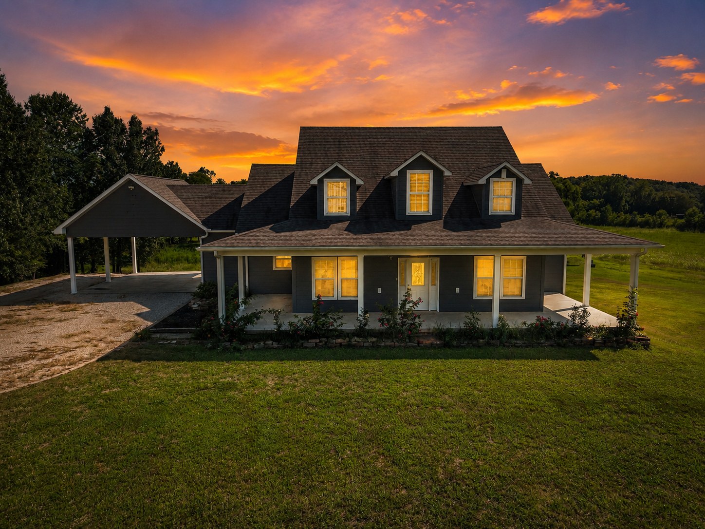 Navy farmhouse with dormers under a fiery sunset sky - HelixMind Real Estate Media